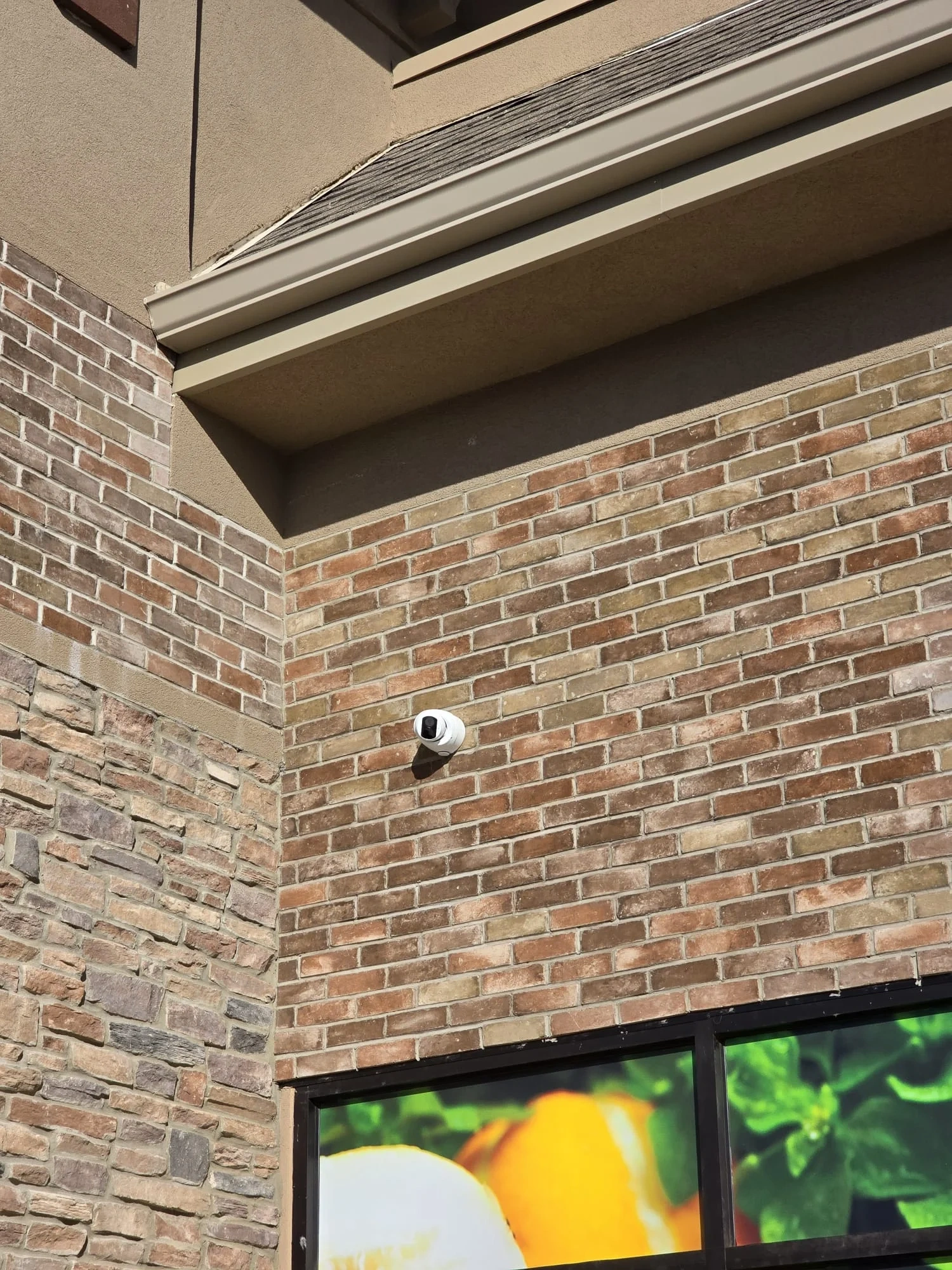 Security camera mounted on an exterior brick wall