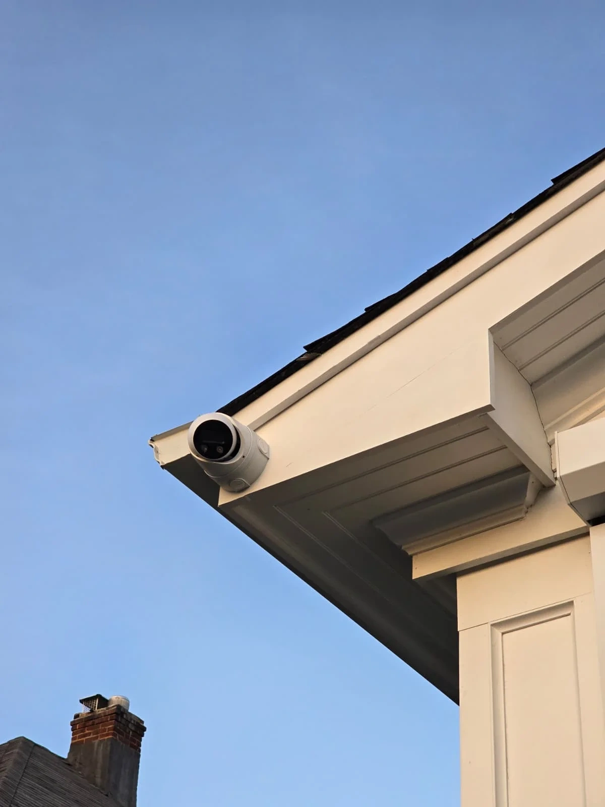Exterior bullet security camera installed under a building eave