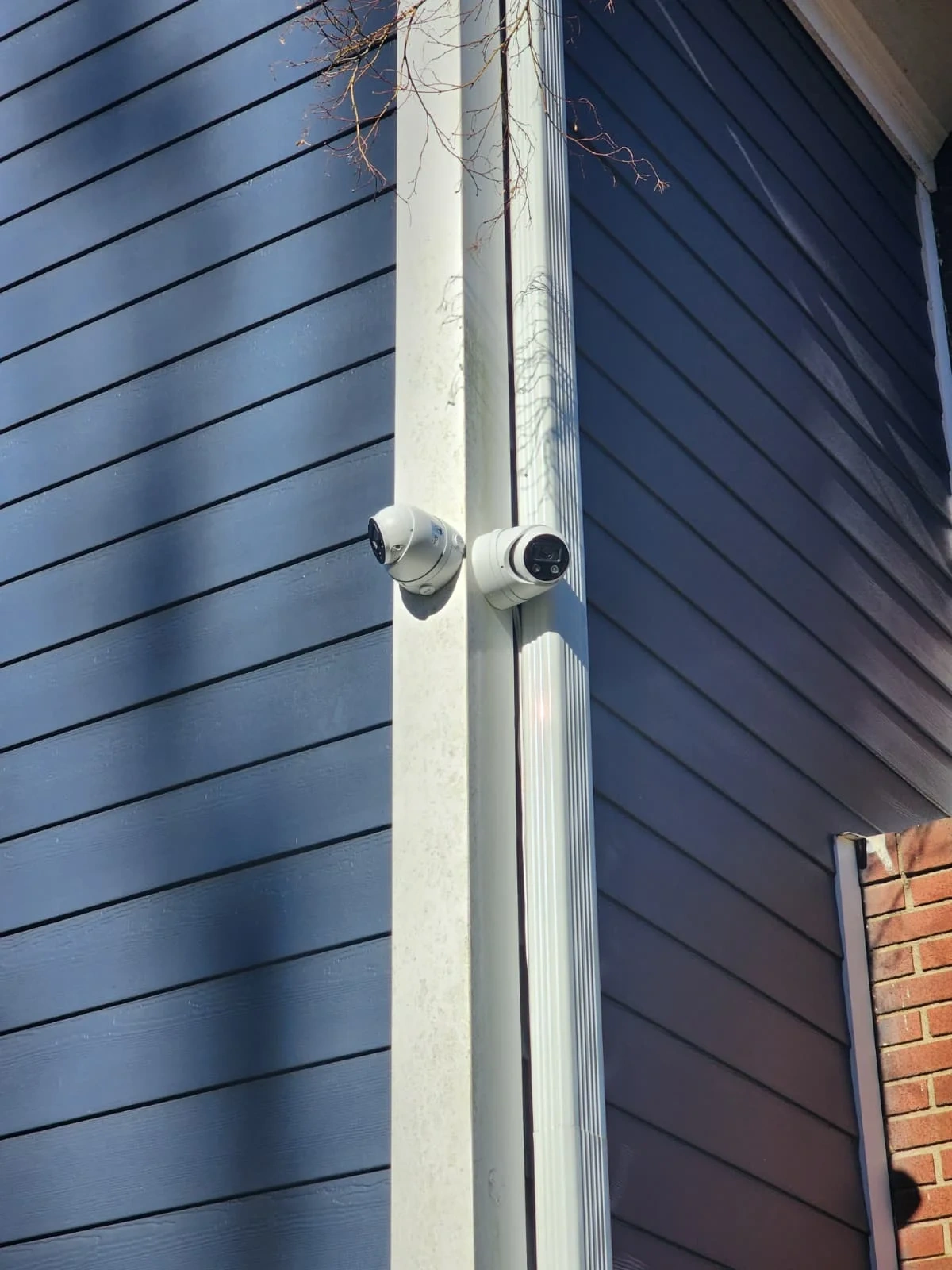 Security camera cable conduit routed along an exterior wall