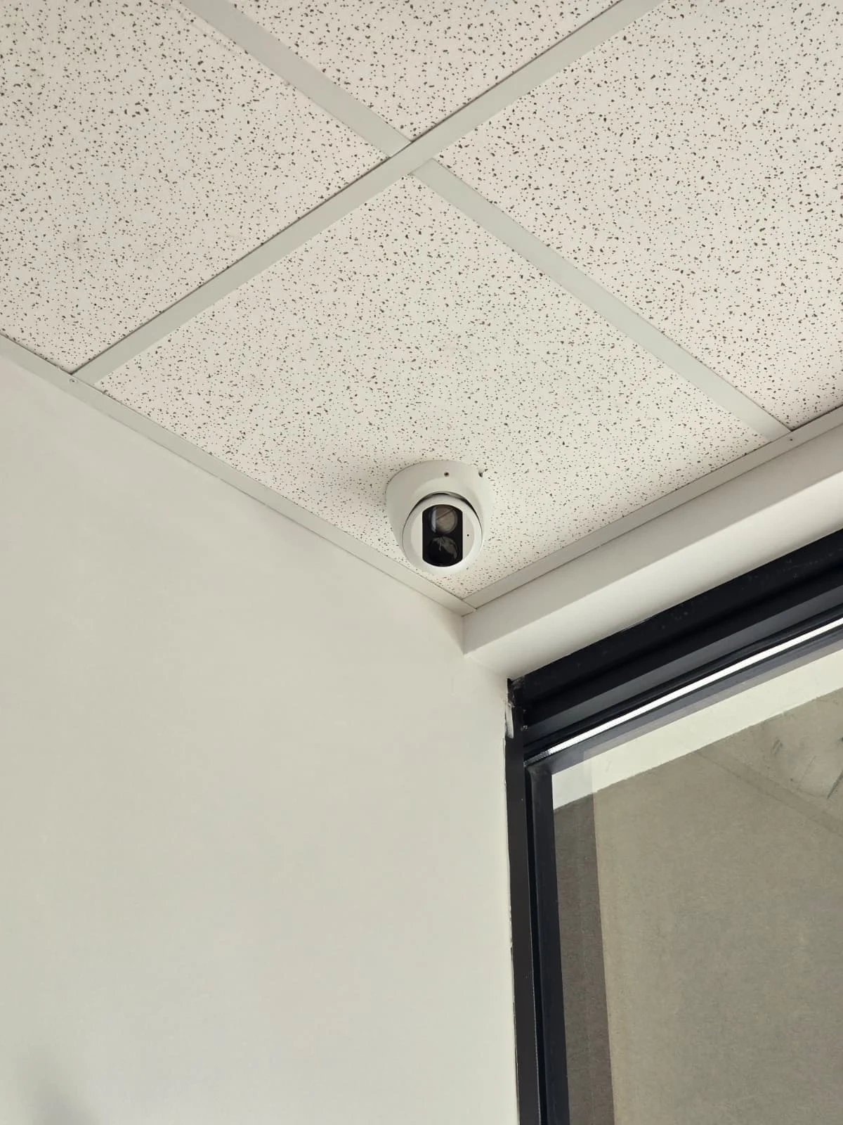 Indoor corner security camera installed above a doorway